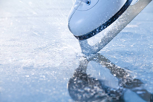 frau skates bremsen eis, frazil fliegen herum - eislaufen stock-fotos und bilder