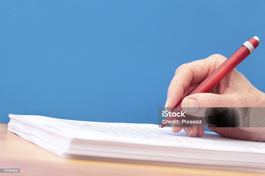 Mão com caneta revisão um manuscrito qualquer idioma - Foto de stock de Examinar royalty-free