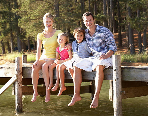 istock Young family sitting by lake 177105550