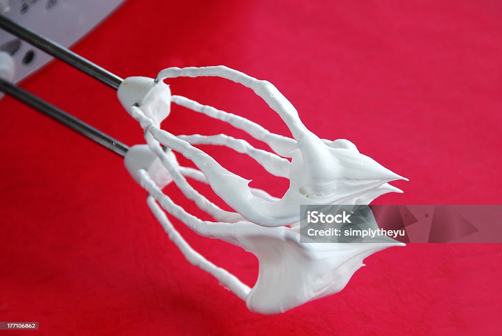 Mixer whisks with cream mixer whisks with white cream over red background Creme Fraiche Stock Photo