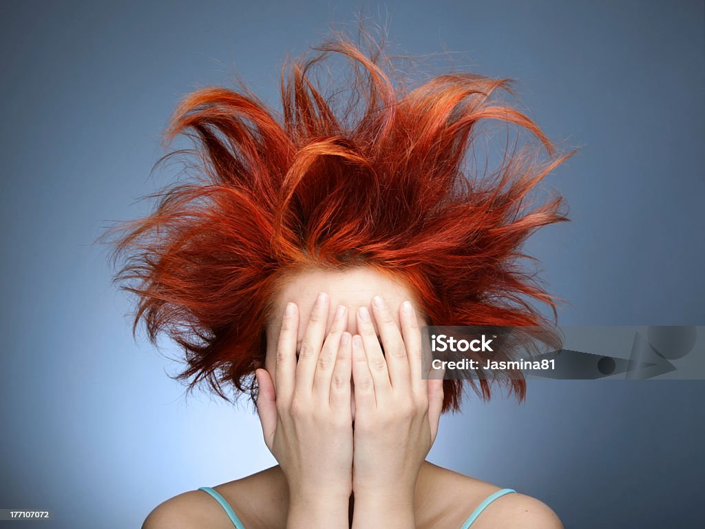 Messy red hair on woman covering her face with her hands Portrait of redhead woman with messy haircut Adult Stock Photo