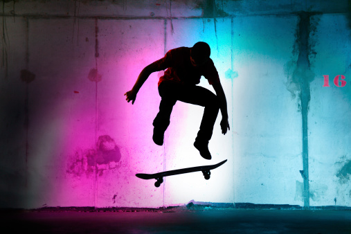 teenager jumping, skateboarding at night black silhouette