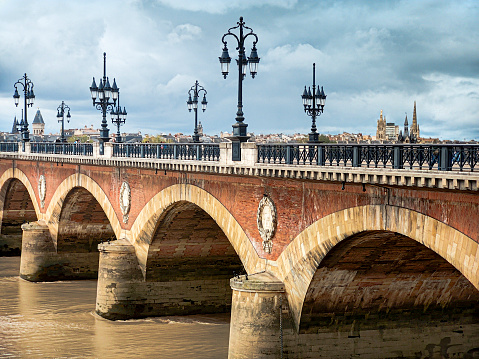 Pont de pierre bridge in fron of Bordeaux old town and Bordeaux Cathedral.
