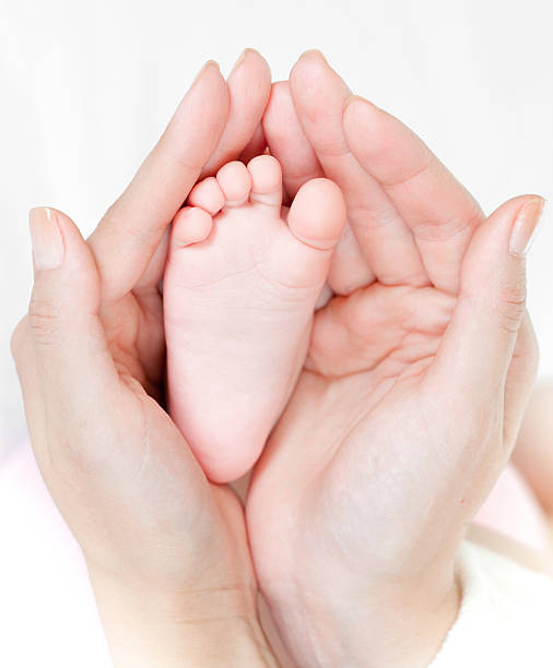 istock Mother's hands carefully keep baby's foot with tenderness 177107477