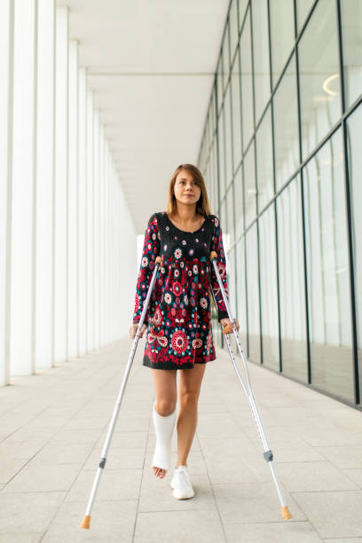 istock Woman with crutches walking down the outside corridor 1771079036