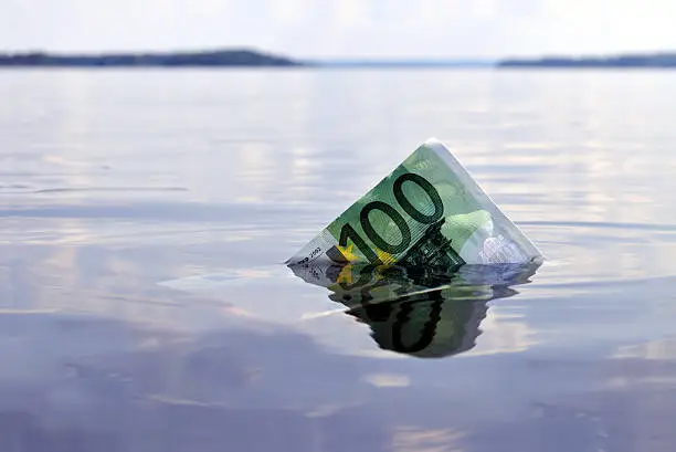 100-euro note sinking into the water, shot on a lake