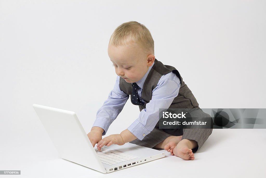 Business Baby on Computer A cute baby boy is dressed in smart business clothes and is with his laptop ready for work. Studio shot Isolated on white. Babies Only Stock Photo