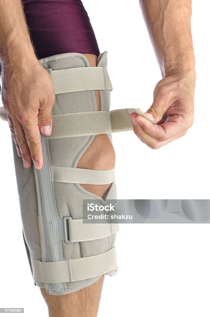 Knee support Male athlete wraps his leg with firm support Adult Stock Photo