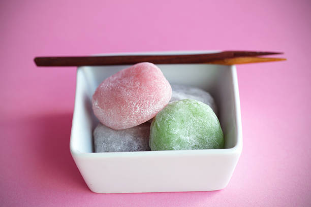 Mochi colorful japanese rice cakes, dessert Mochi colorful japanese rice cakes with wooden fork on pink red bean dessert stock pictures, royalty-free photos & images