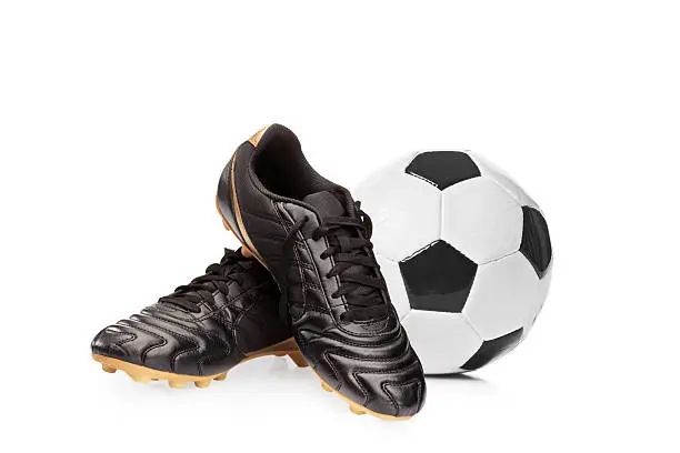 Football shoes and a football isolated on white background