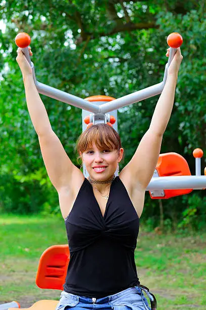 A young woman trained on a sport device in city park in city Saarlouis - Saarland / Germany.