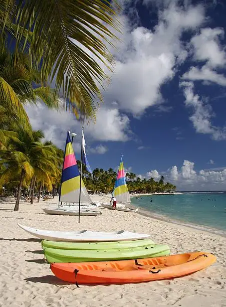Beautiful caribbean beach with a colorful jolly boats and kayaks