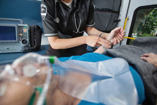 Detail of EMT worker measuring pulse on arm of senior woman patient