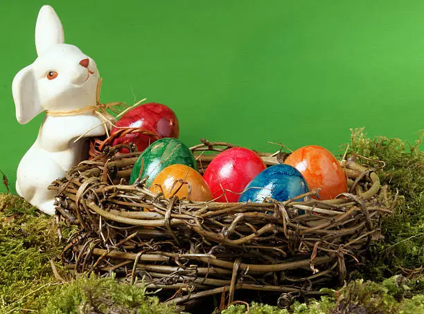 "A white hare stands in one, with brightly painted Easter eggs to full, nest from twisted pasture branches."