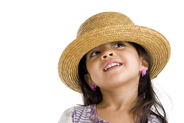 He wears a straw hat and jokingly sticks out her tongue and squints.