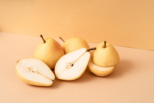 Podium for exhibitions and product presentations. Beautiful beige background with yellow pears. Abstract minimal empty background composition for product presentation