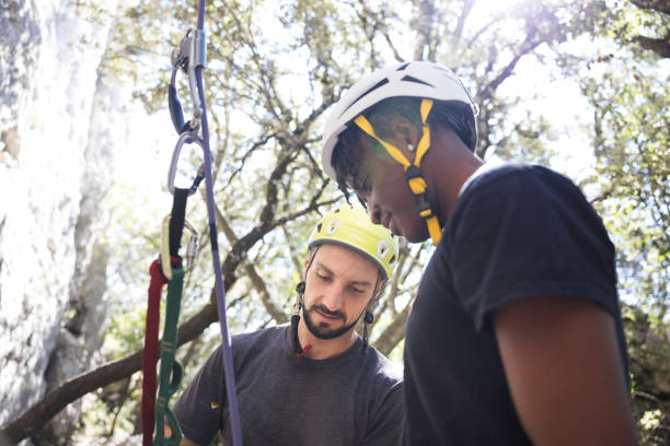 Climber teaching the use of climbing fall protection and climbing rope. Climbers preparing their climbing equipment. Outdoor climbing concept.