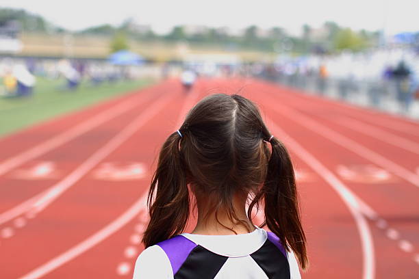 Anticipation at the start of a race "A picture of a youth girl at the starting line, about to compete in a track & field event." womens track stock pictures, royalty-free photos & images