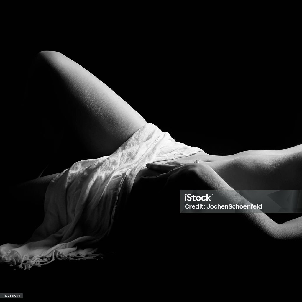 Classical nude of a beautiful young woman "Classical closeup nude of a beautiful young woman lying in front of black background covered with a white towel, black and white photo" Abdomen Stock Photo