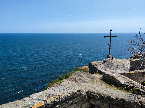 metal cross on top of Cape Kaliakra in Bulgaria against the sea horizon.