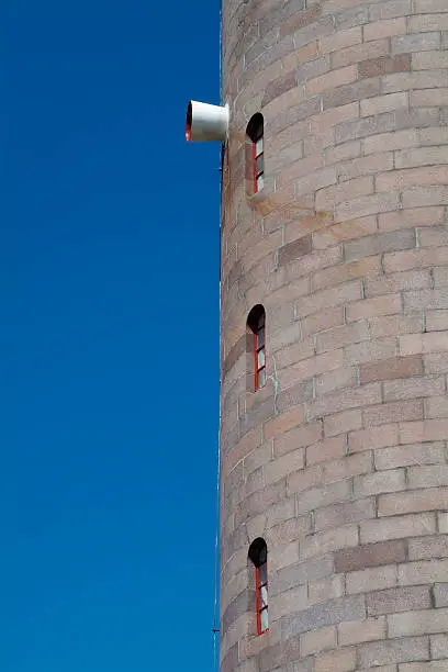 Detail of a traditional style lighthouse with foghorn and three windows