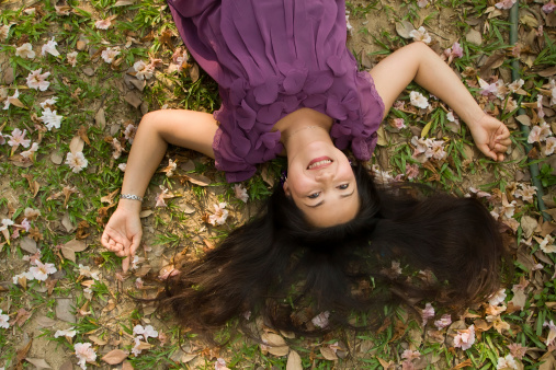 happy asian woman lying on grass and smiling