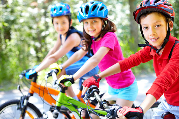 Young cyclist Three little children riding their bikes bicycle cycling school child stock pictures, royalty-free photos & images