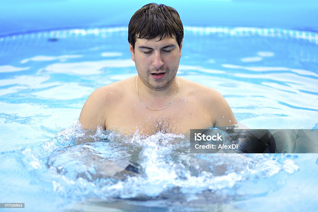 Joven hombre descanse en el área de la piscina - Foto de stock de Adulto libre de derechos