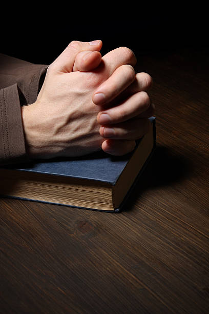 istock Hands folded in prayer over a Holy Bible 177121009