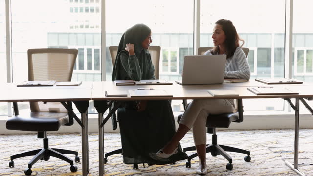 Multicultural businesswomen lead formal talk in conference room