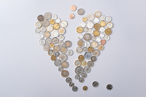 heart-shaped arrangement crafted from coins originating from different countries, with each coin showcasing the portraits of renowned figures featured on their currency.