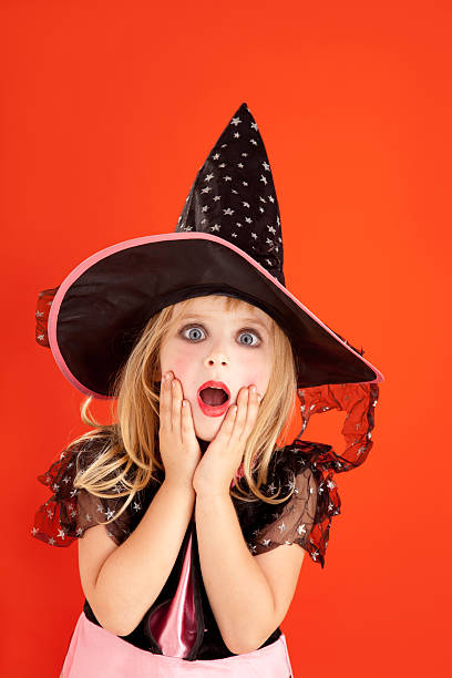 Little girl in a black hat on a halloween spider web.
