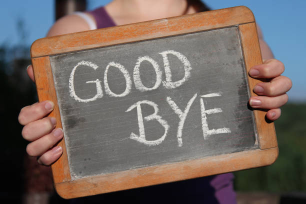 good bye written with chalk on slate shown by young female