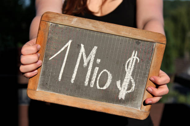 istock 1 Mio $ written with chalk on slate shown by young female 1771225497
