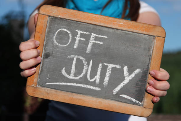 istock off duty written with chalk on slate shown by young female 1771226065
