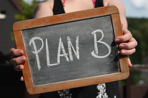 plan b written with chalk on slate shown by young female
