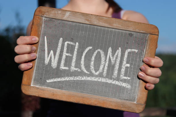 若い女性が示したスレートにチョークで書かれた歓迎 - welcome sign ス��トックフォトと画像