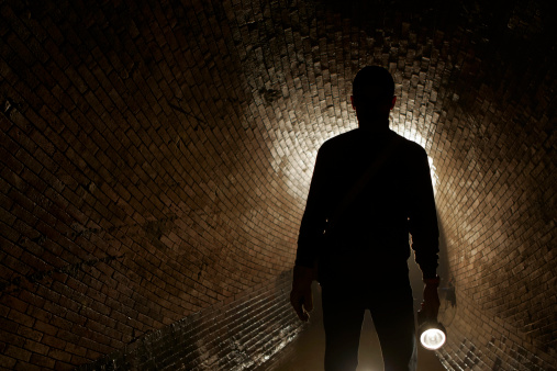 Silhouette man in underground old sewage treatment plant.