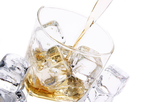istock Clear short glass with ice cubes and alcohol being poured 177123629