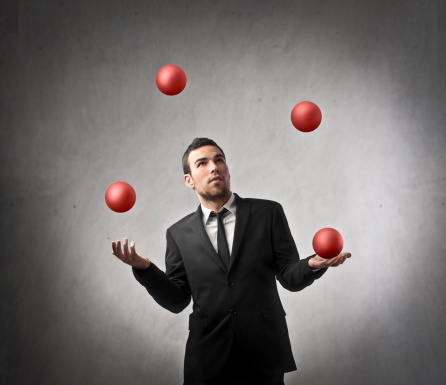 Young businessman juggling with some spheres