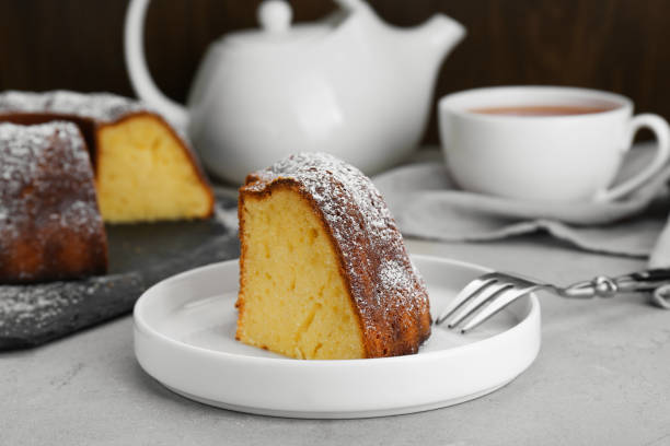 istock Piece of homemade yogurt cake with powdered sugar on light grey table 1771264409
