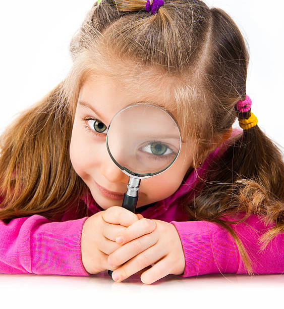 istock girl looking through a magnifying glass 177127452