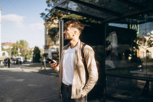 istock The handsome man using smartphone while waiting at the bus station 1771275645