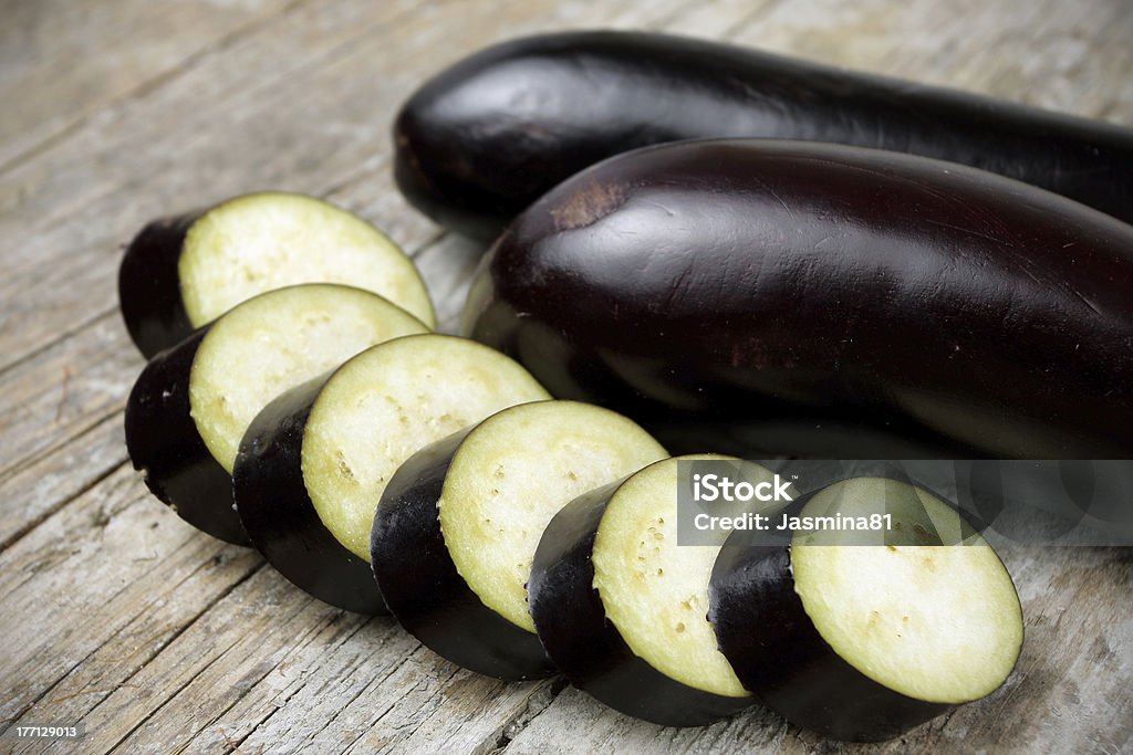 Eggplant on wooden table Sliced eggplant on wooden table Crop - Plant Stock Photo