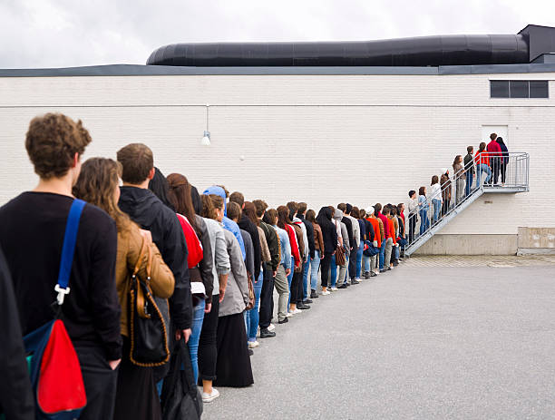Waiting in Line Large group of people waiting in line queuing stock pictures, royalty-free photos & images