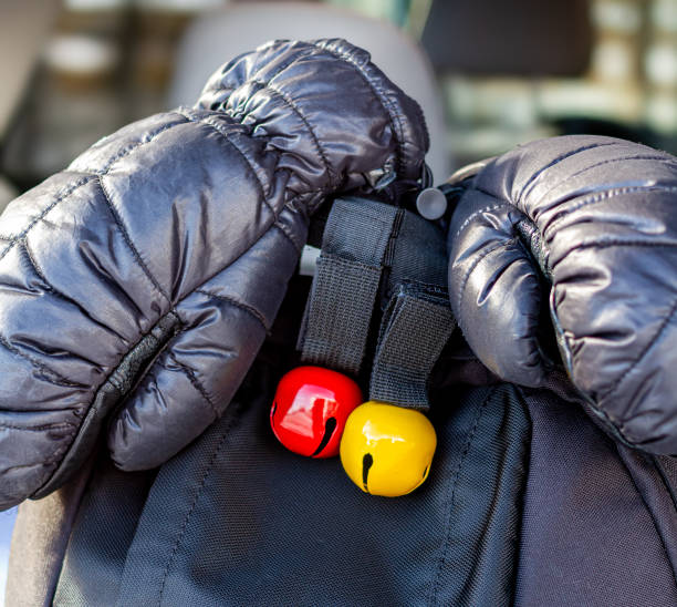 istock Puffy black winter gloves on black backpack with red and yellow bear bells 1771294161