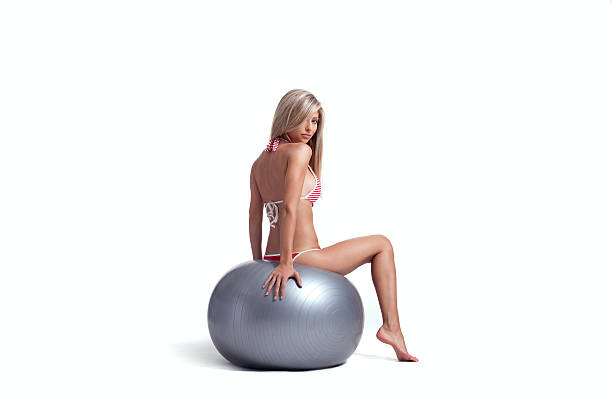 Blond girl sitting on a Pilates ball stock photo
