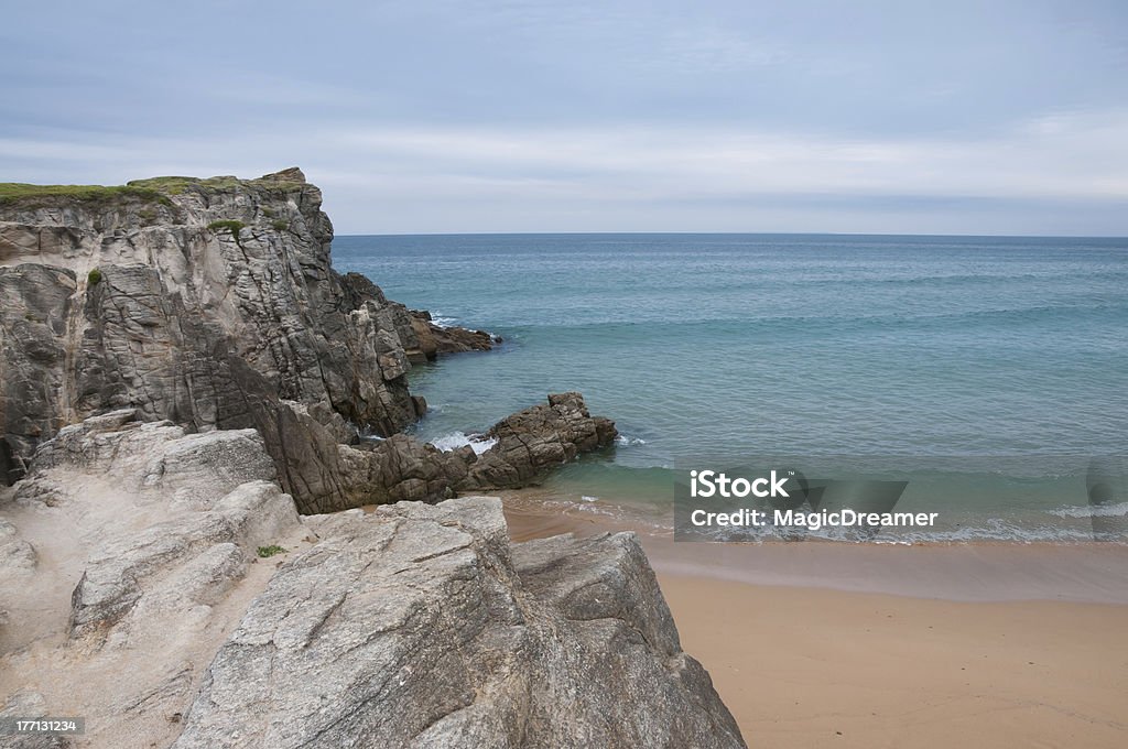 Forbidding coastline Cliffy coast in Brittany, France. Play of colors with the different blue and green of the ocean. Beach Stock Photo