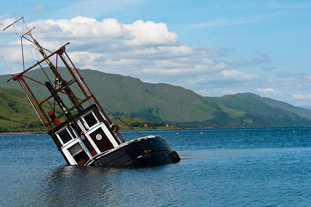 Boat, Partially submerged fishing vessel in Loch Linnie A foundered and partially submerged fishing vessel or samon farm support vessel in Loch Linnie just north of the village of Corran in Ardgour at  56 fishing boat sinking stock pictures, royalty-free photos & images