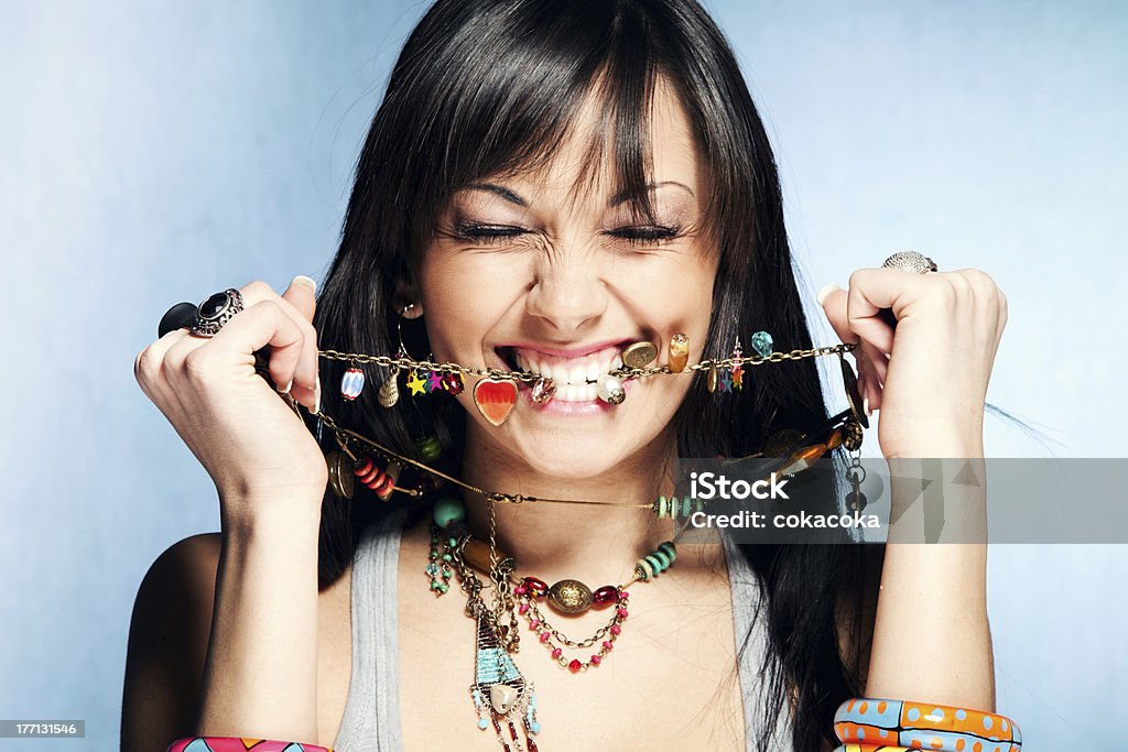 dandy woman pretty dandy young woman bite her necklace, studio shot Personal Accessory Stock Photo